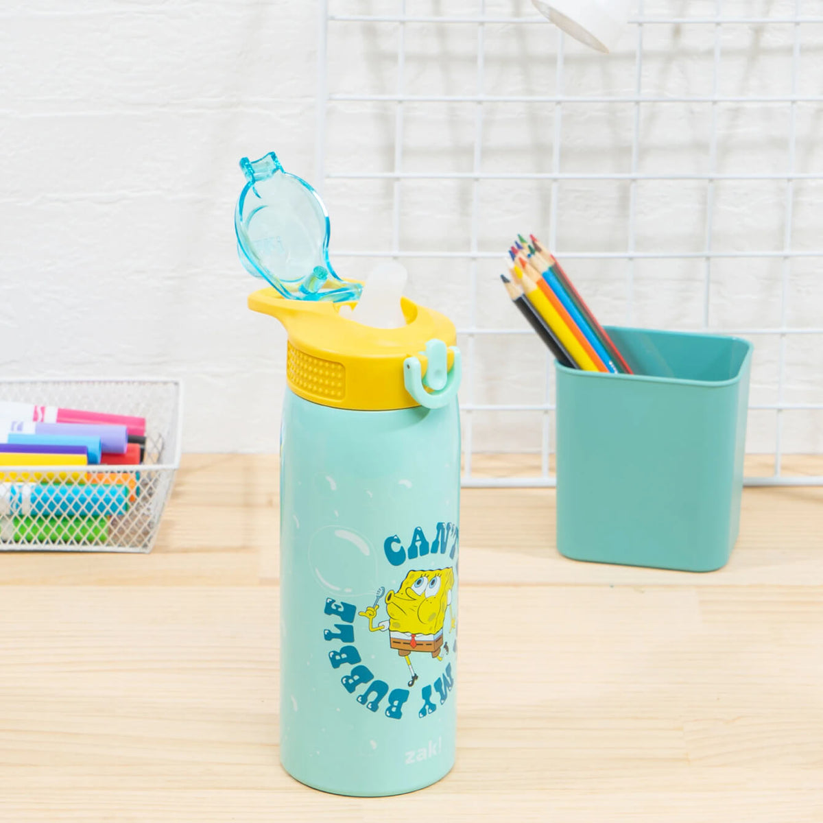 Kids green and yellow water bottle on school room desk