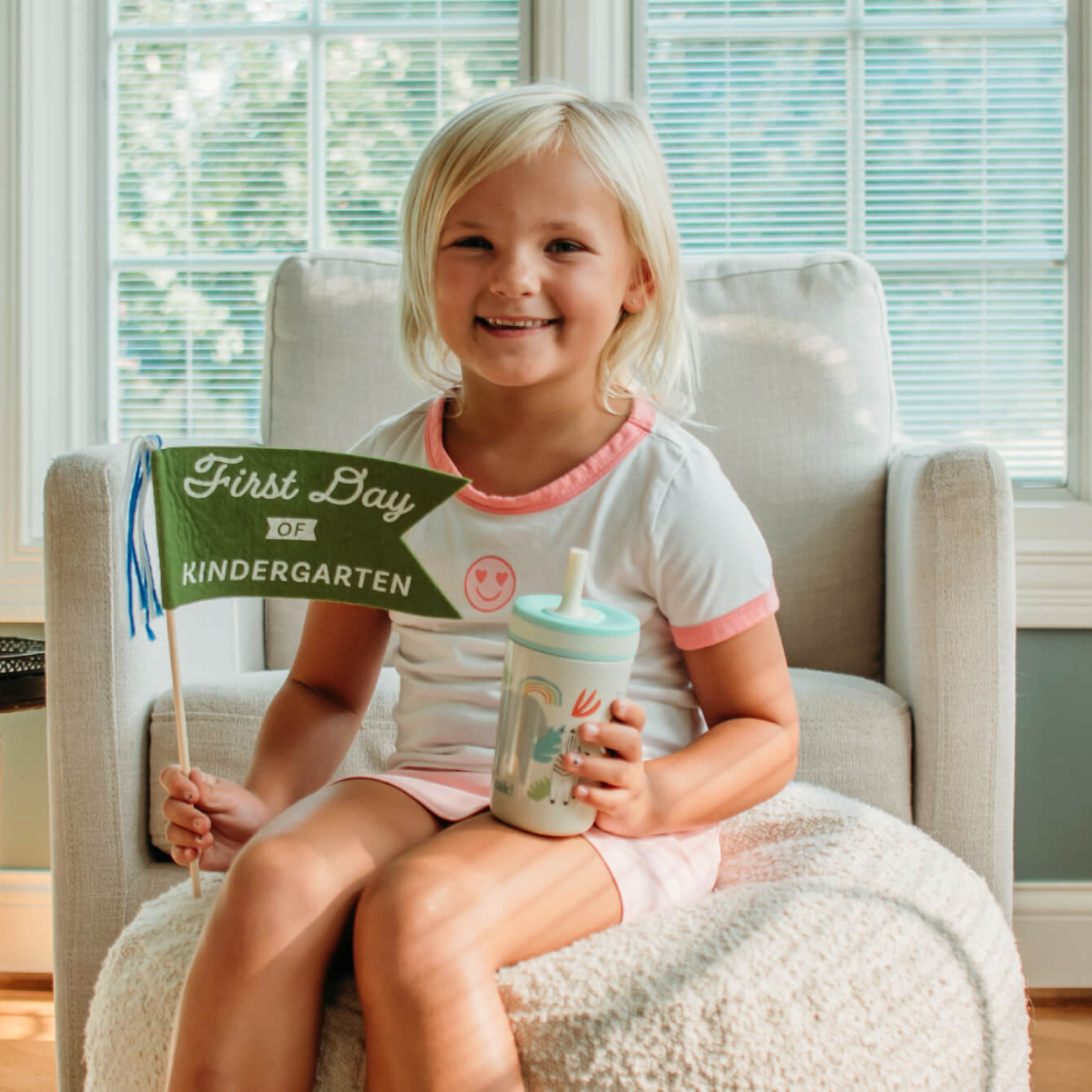 girl sitting on couch holding tumbler with animal designs