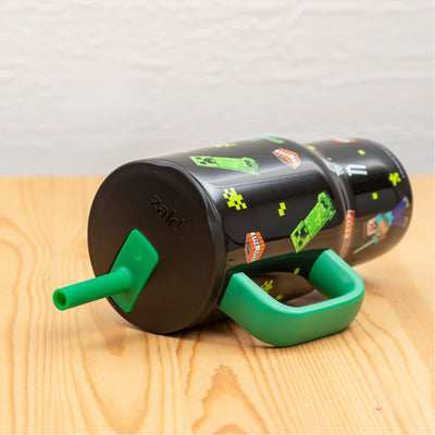 Kids Minecraft straw tumbler laying on side on light wood tabletop