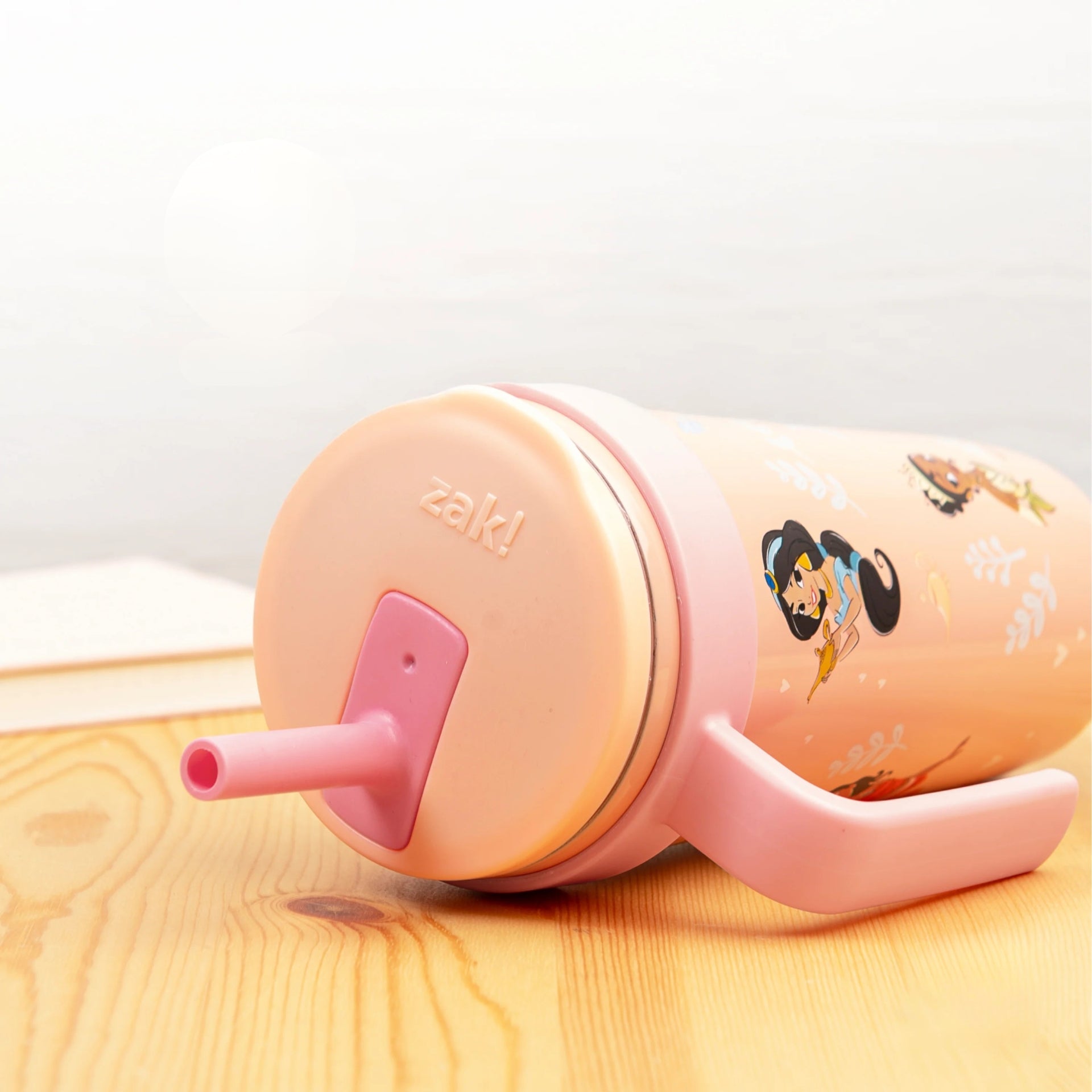 Disney Princess zak sippy cup with straw and lid on a wooden surface