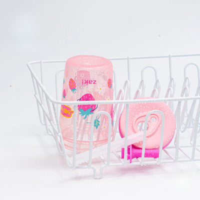 Pink kids tumbler in a white dishwasher rack on a light gray background