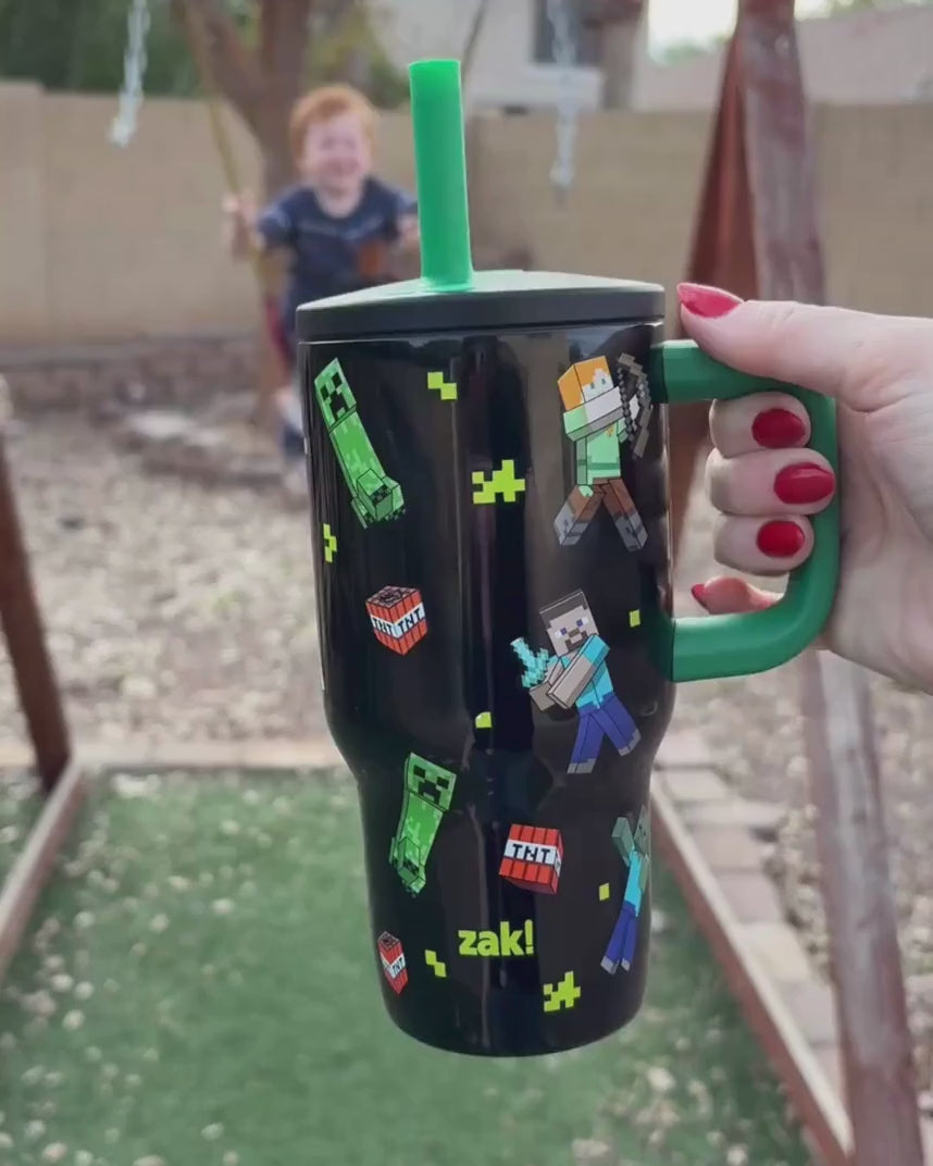 Load video: Boy drinking from zak Minecraft straw tumbler with handle outside