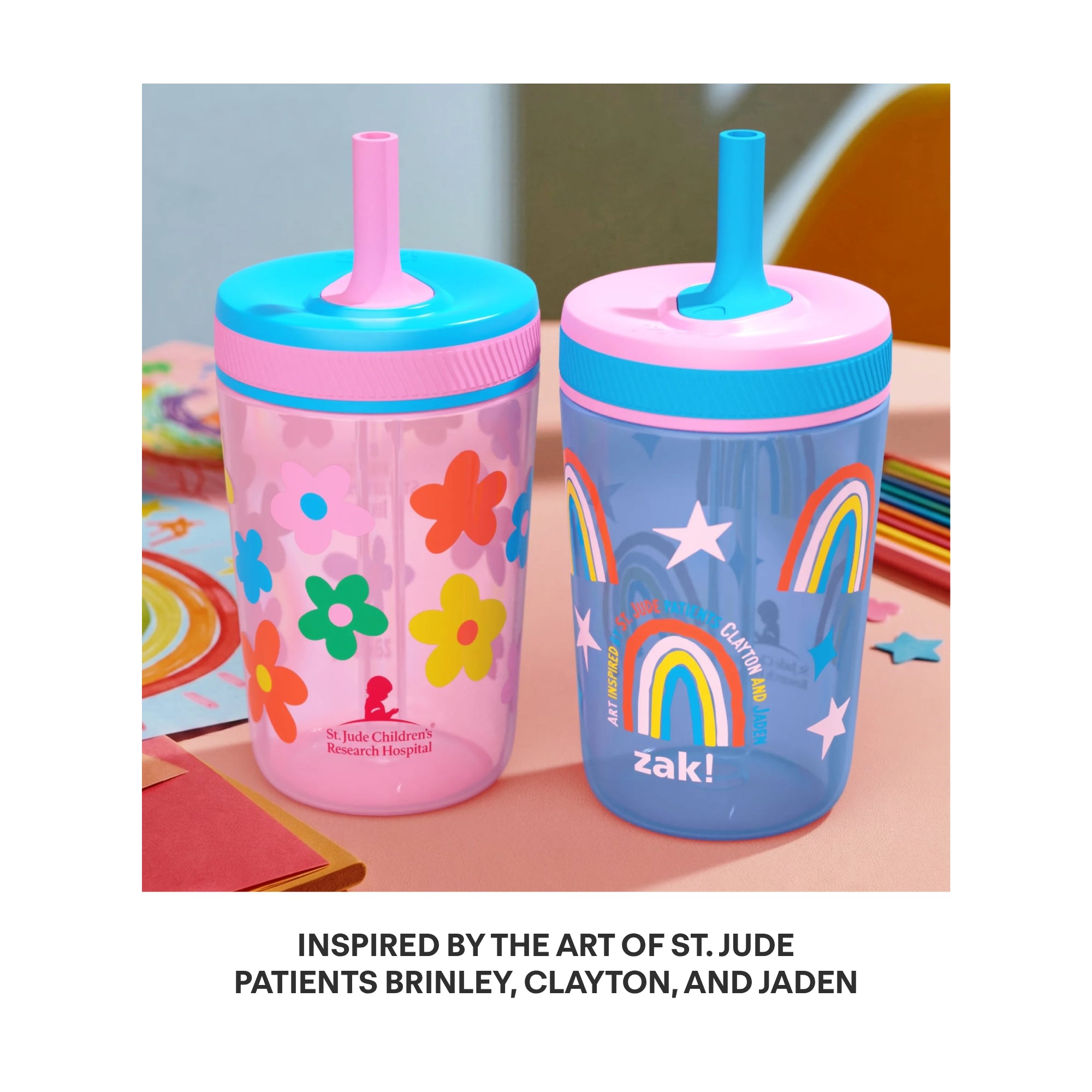 Two colorful plastic tumbler cups with straw lids are shown side by side on a tabletop. The left cup is translucent pink with multicolored flower prints and a pink lid with a blue straw.