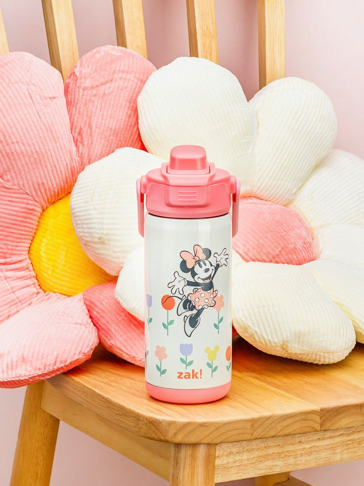 Pink zak water bottle with Minnie Mouse design on a wooden chair with decorative cushions.