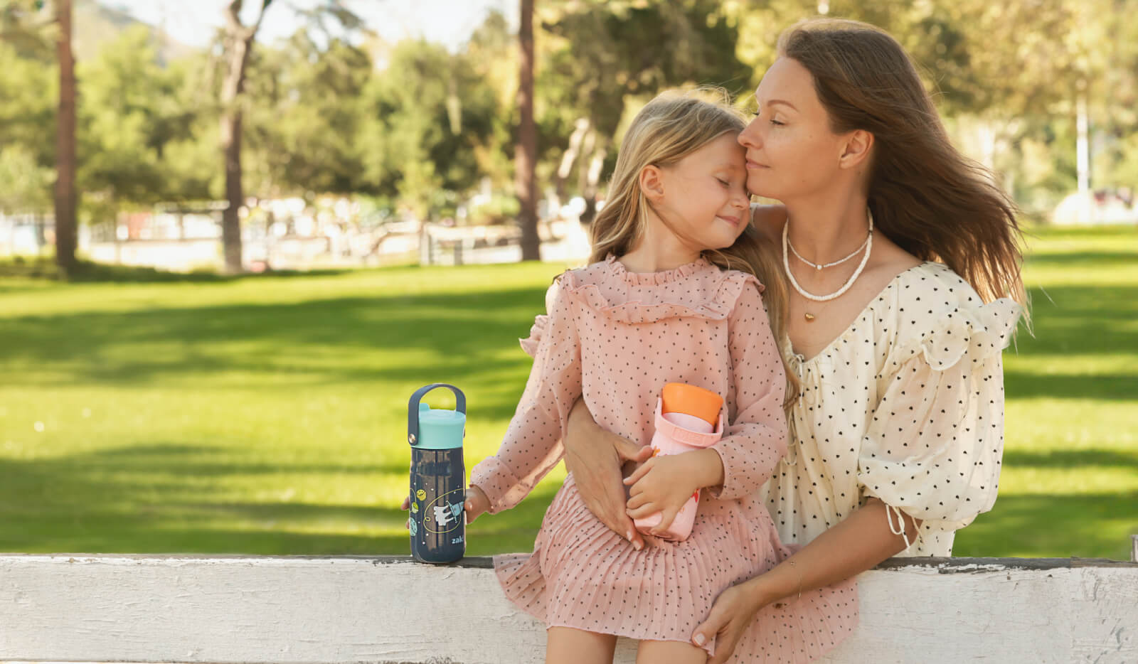 Woman and child sitting in park - Zak Designs St. Jude drinkware collection